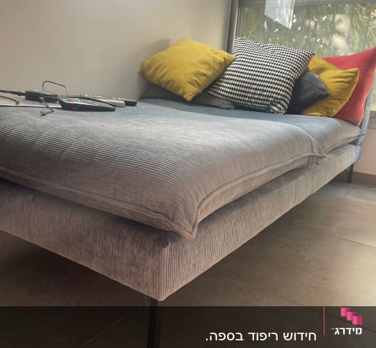 כריות צבעוניות על ספה מרופדת אפורה